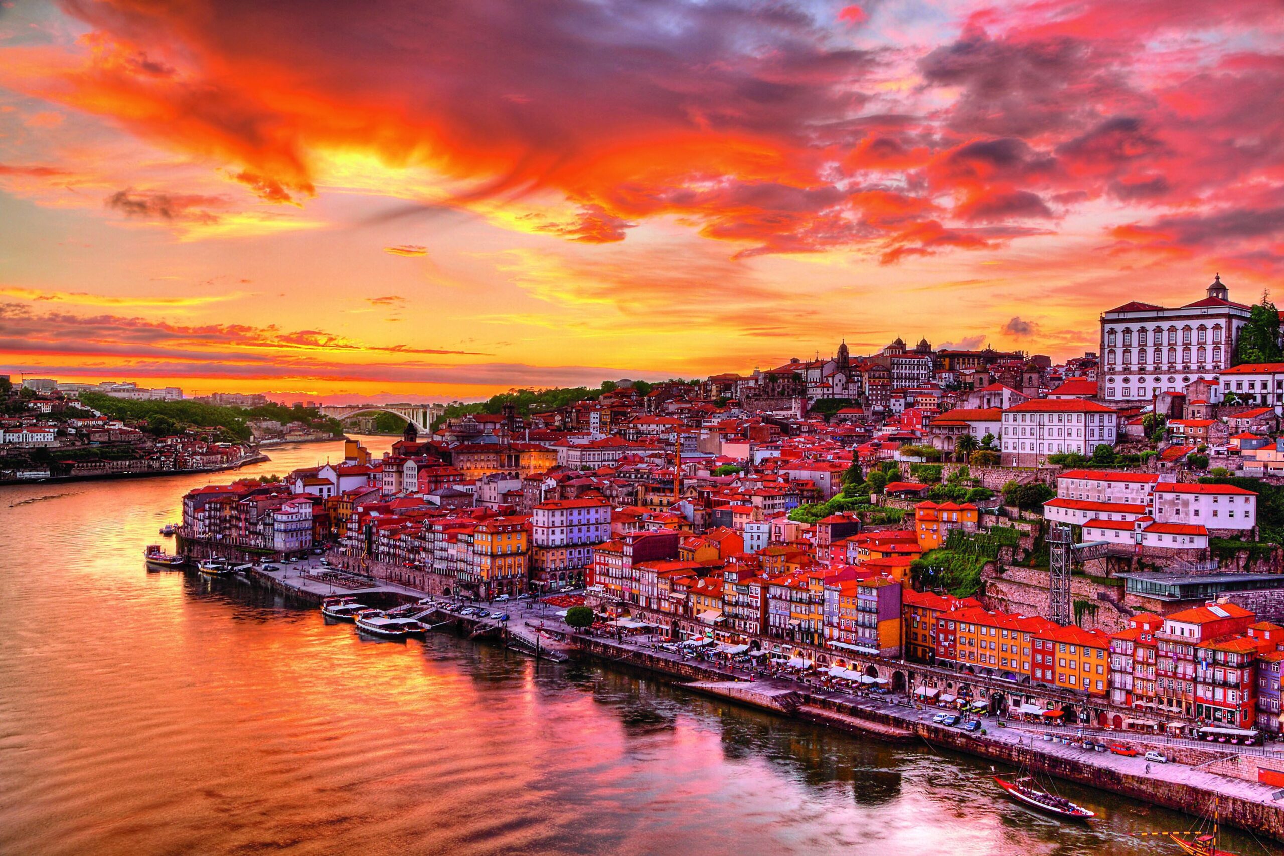 Vue depuis le Pont Dom Luís I et du Jardim do Morro à Vila Nova de Gaia, offrant une perspective panoramique sur Porto et le Douro, capturée en fin de journée avec les belles teintes du soleil couchant.